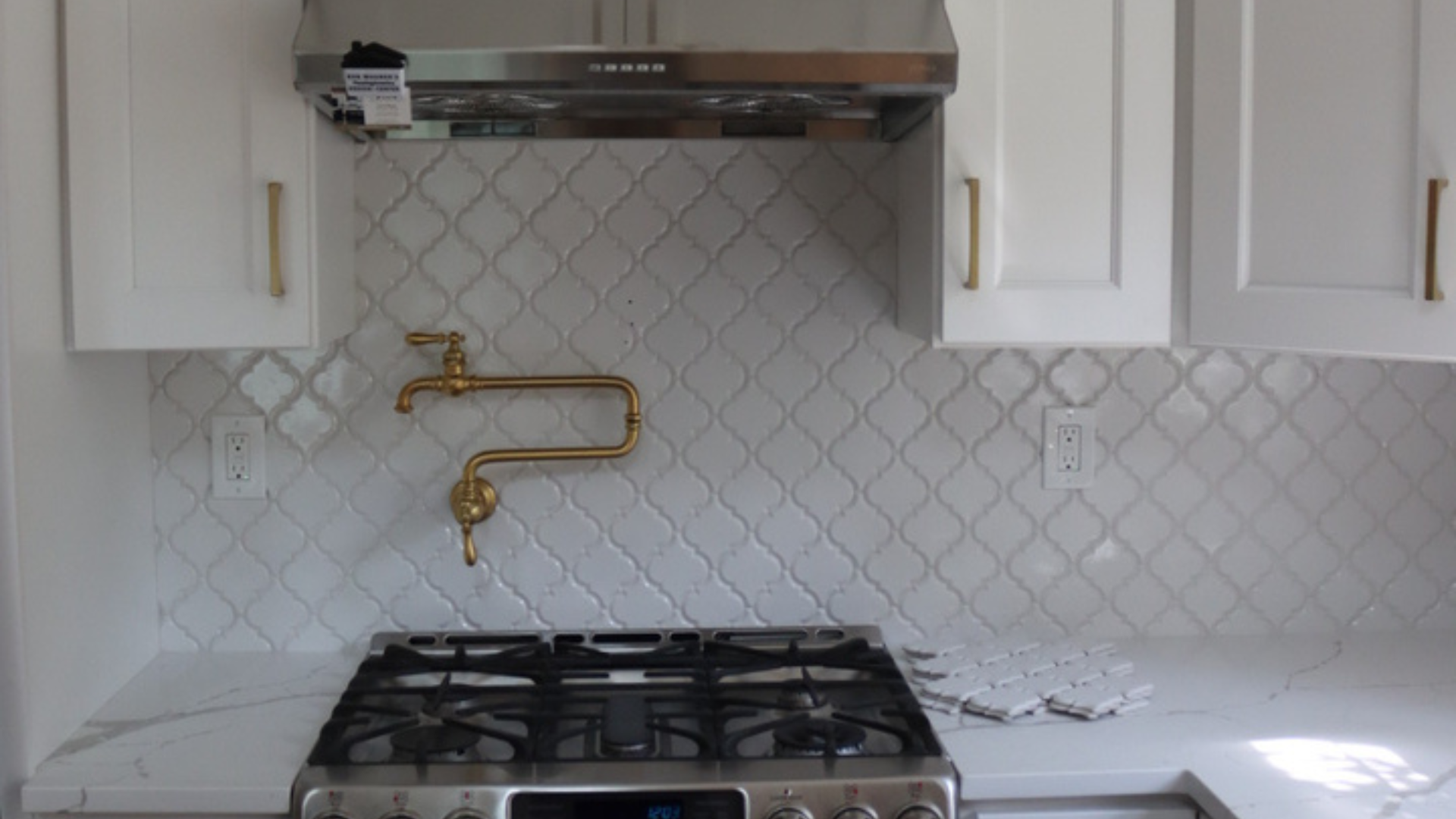Modern geometric porcelain tile backsplash with custom range hood